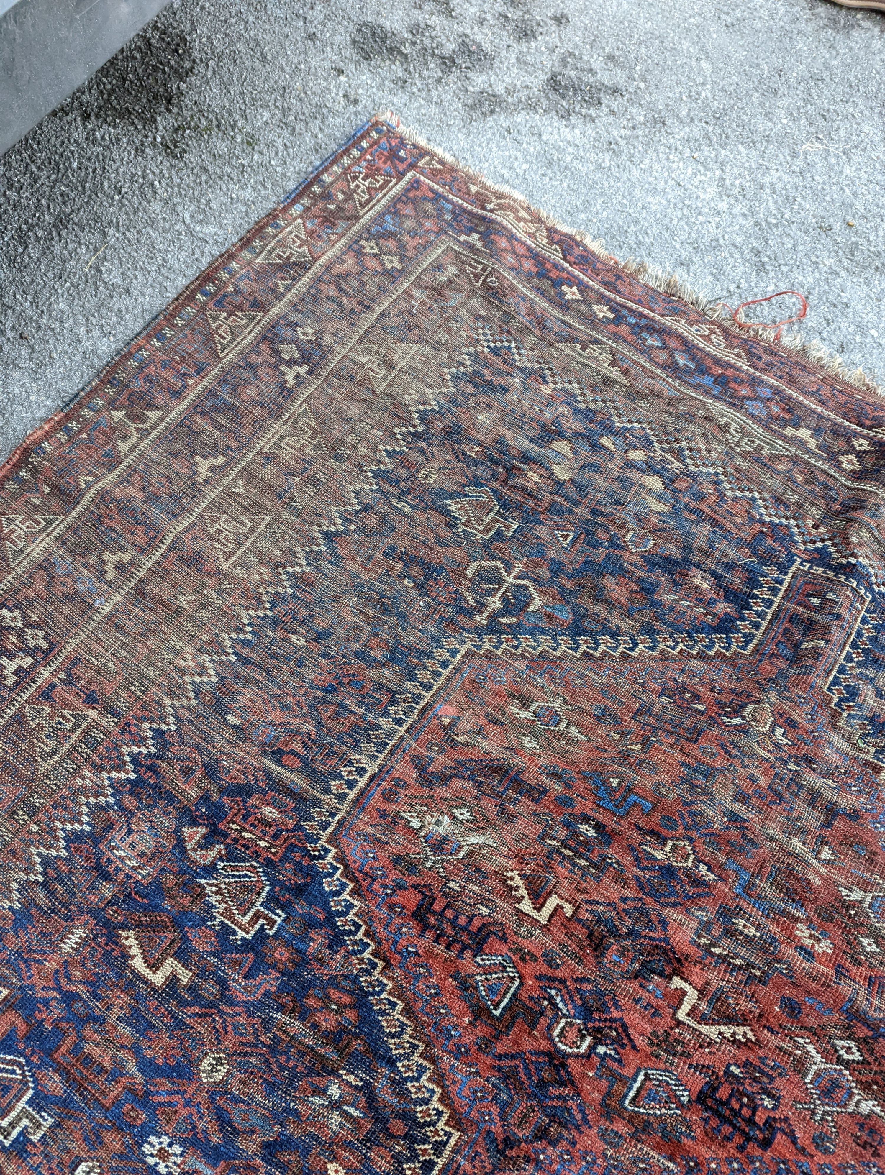 An antique Shirvan red ground carpet (worn), 295 x 207cm